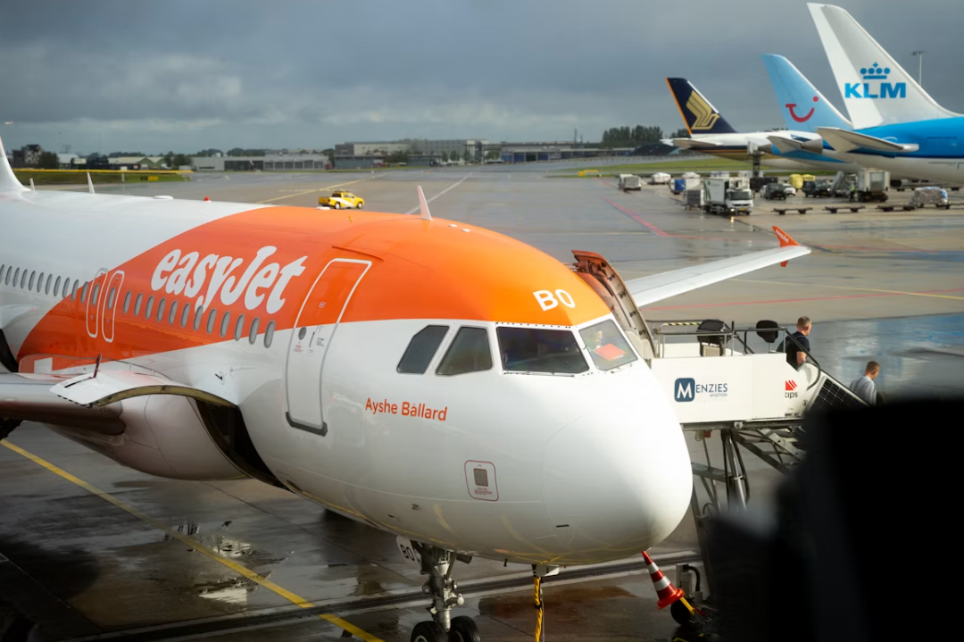 An orange and white EasyJet jetliner sitting on a runway