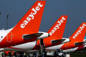 Three orange and white EasyJet jetliners sitting on a runway