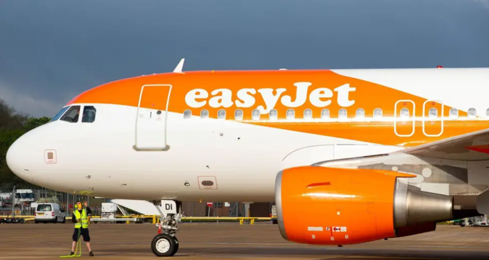 A large orange and white EasyJet jetliner sitting on a runway