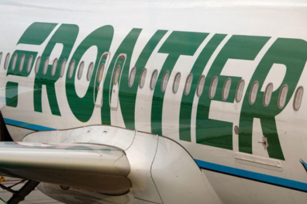 A close-up view of the side of a white and green Frontier jetliner
