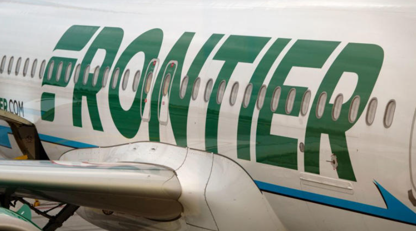 A close-up view of the side of a white and green Frontier jetliner