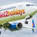 A close up shot of a Jet2 Holidays plane flying in a cloudy sky