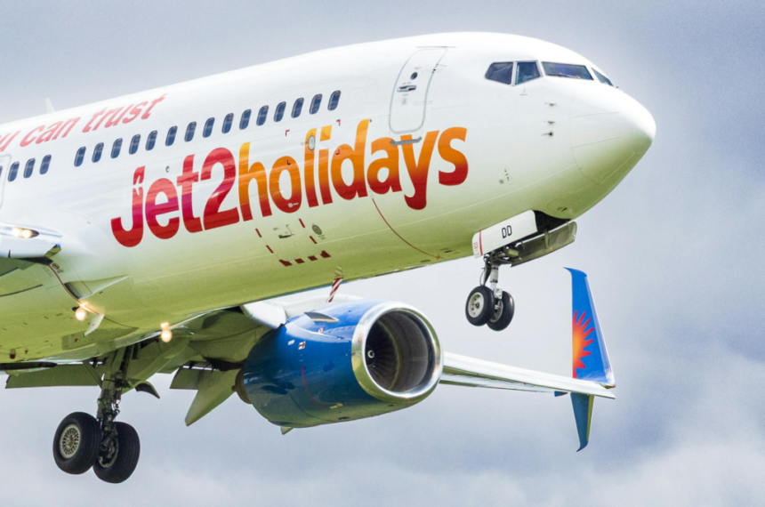 A close up shot of a Jet2 Holidays plane flying in a cloudy sky