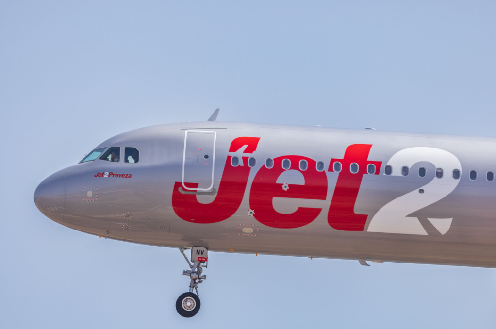 Close up of a grey Jet2 airplane in flight in a blue sky