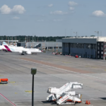 Four large white jetliners sitting on an airport runway.