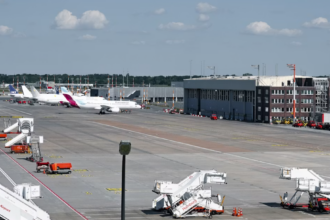 Four large white jetliners sitting on an airport runway.