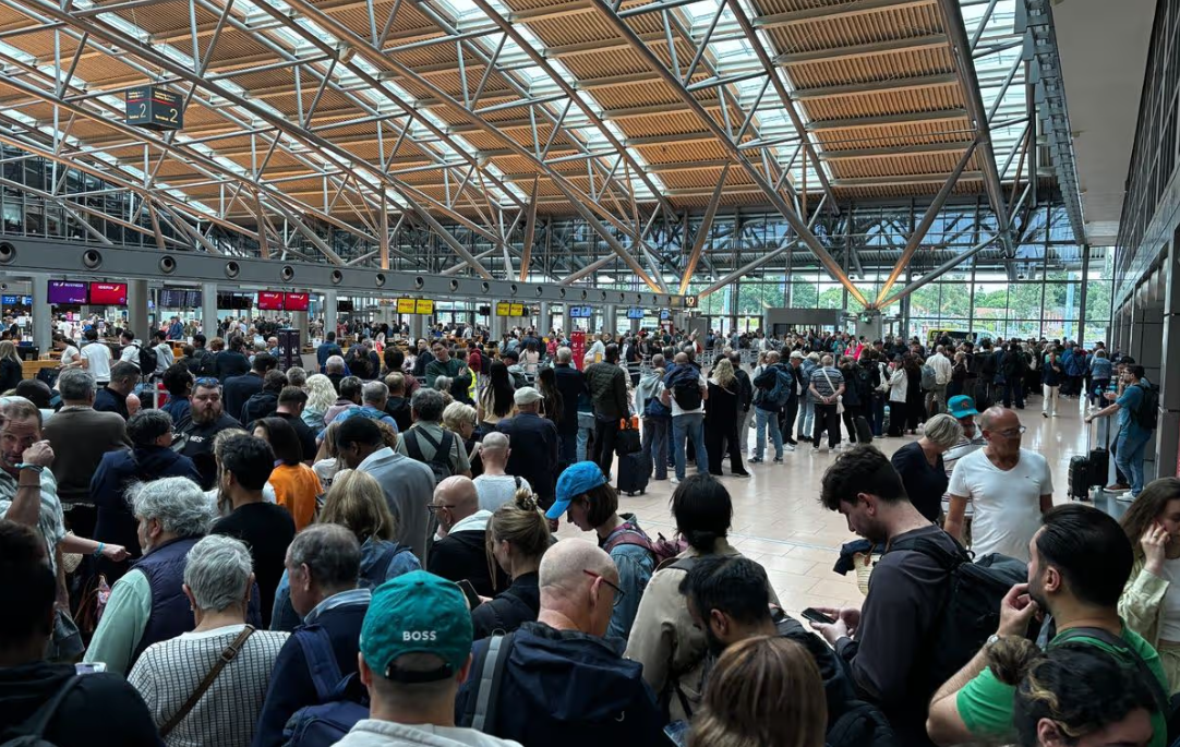 A large crowd of people waiting in an airport terminal.