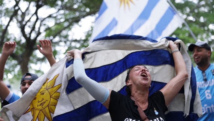 A woman celebrating and holding a blue and white flag, with trees in the background.