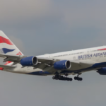 A large white jetliner flying through a cloudy sky