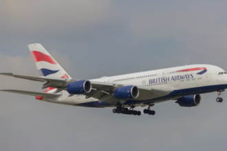 A large white jetliner flying through a cloudy sky