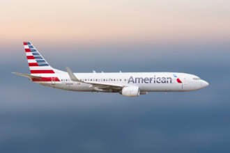 A large white jetliner flying through a cloudy sky.