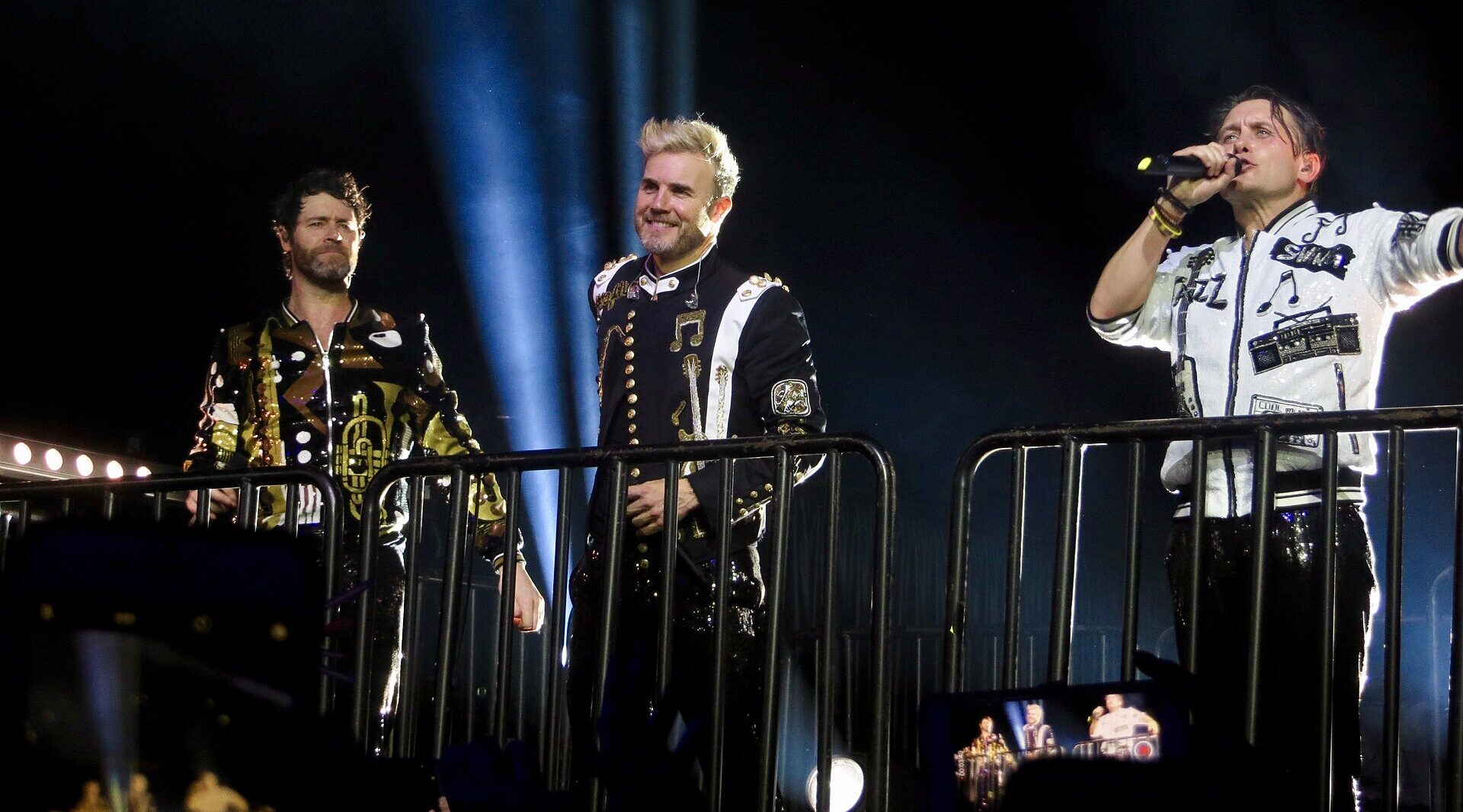 That That performing in Glasgow. Lights in the background, rails in the foreground.