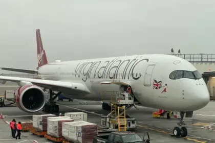 Virgin Atlantic Airbus A350-1000 on runway, being refulled, with palletts and workers surrounding