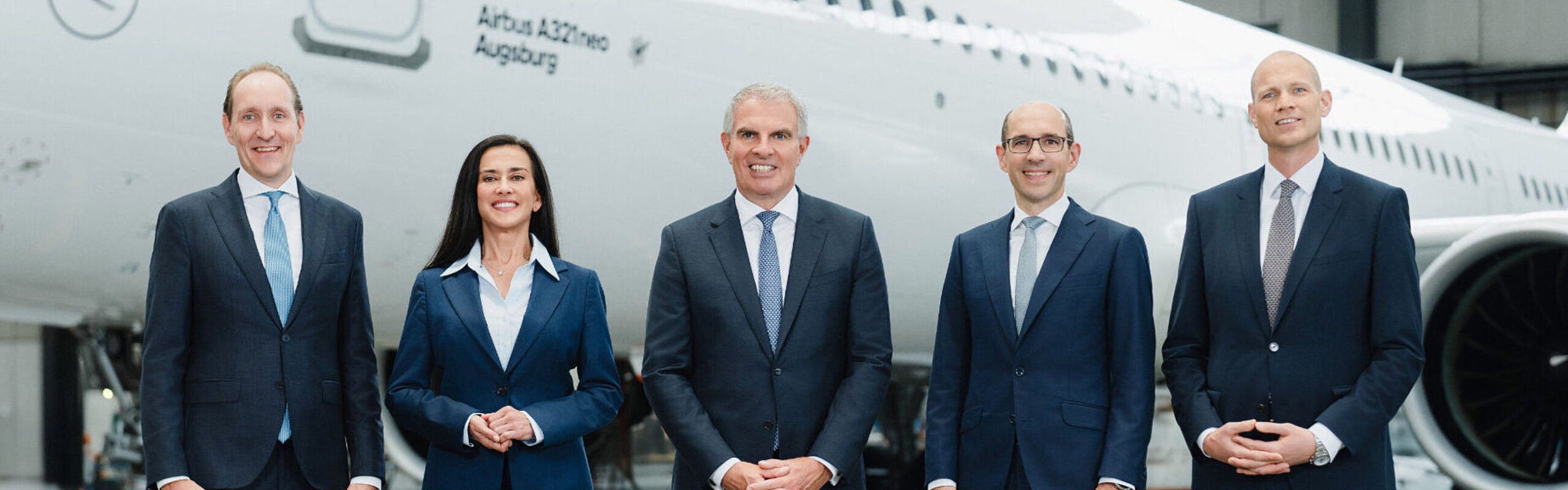 five members of the Lufthansa Executive Board standing in a line in front of an Airbus A321neo