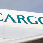 The fuselage of a Cathay aircraft with "Cargo" written in green on a white plane.