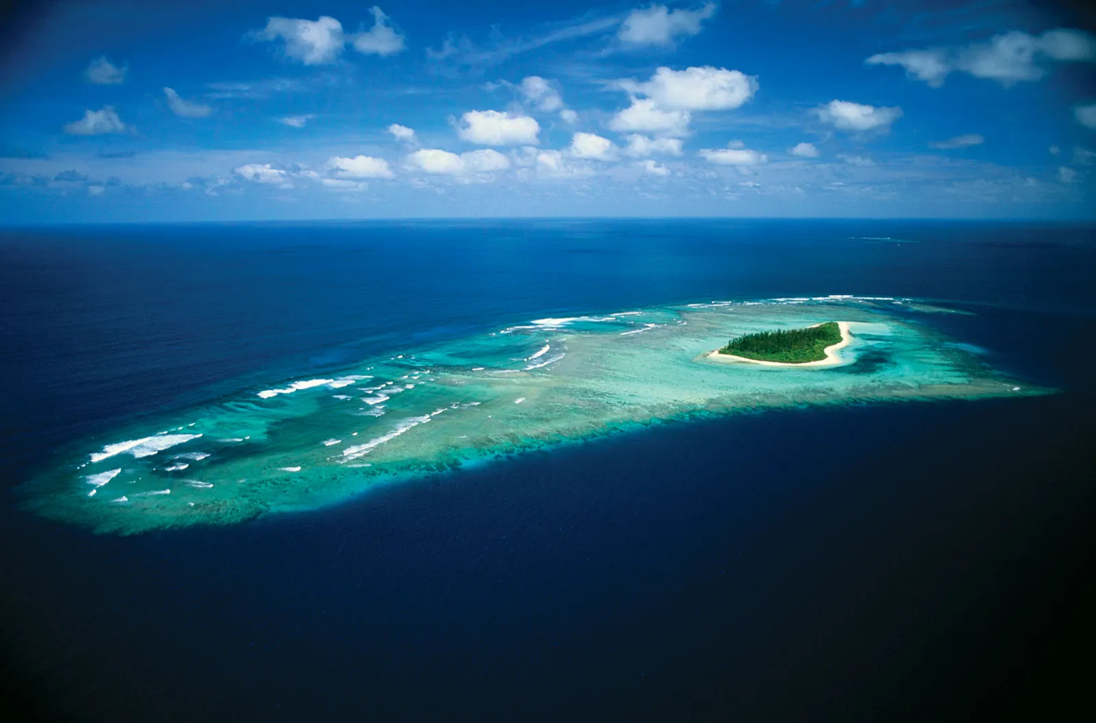 Birds Eye view of one of the loyalty islands surrounded by deep blue sea