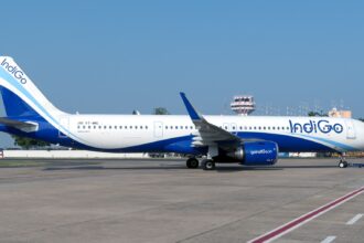 IndiGo Airbus A321neo (VT-IME) on the apron with an air traffic control tower visible in the background.