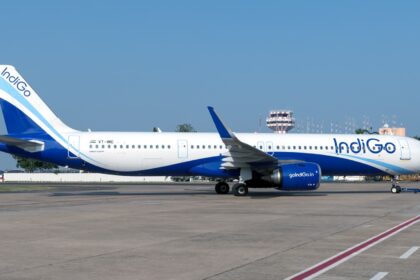 IndiGo Airbus A321neo (VT-IME) on the apron with an air traffic control tower visible in the background.