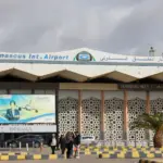 Damascus Airport exterior shot building most of image, cloudy sky above.