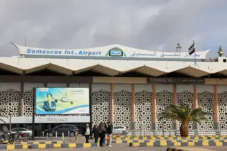 Damascus Airport exterior shot building most of image, cloudy sky above.