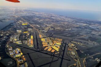 View of Amsterdam Airport Schipol from an airport. The runways are visible and one can see the many lights of the terminals and its surrounding.