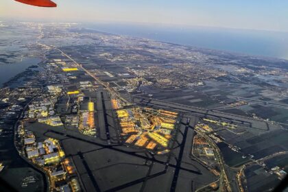 View of Amsterdam Airport Schipol from an airport. The runways are visible and one can see the many lights of the terminals and its surrounding.