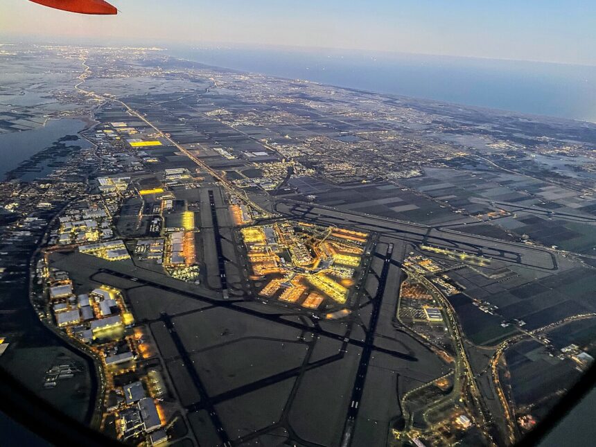 View of Amsterdam Airport Schipol from an airport. The runways are visible and one can see the many lights of the terminals and its surrounding.