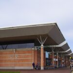 The outside of terminal at Jersey Airport. The sky is very cloudy with the blue sky peeking through