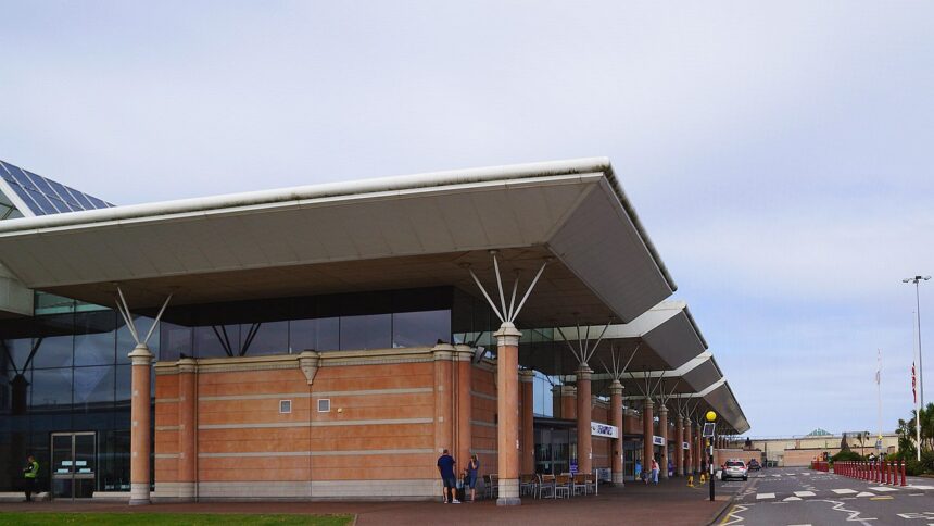 The outside of terminal at Jersey Airport. The sky is very cloudy with the blue sky peeking through