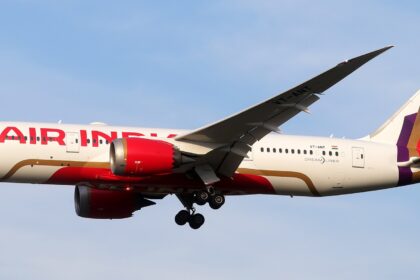 Side view of the full length of Air India's VT-ANT with its landing gear extended in the sky.