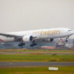 Emirates flight EK717 touching down on the runway.