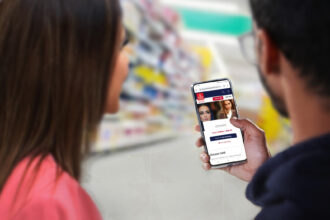 A man and woman, with only the backs of their heads showing, are holding and looking at a phone