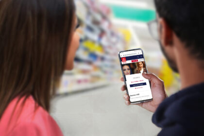 A man and woman, with only the backs of their heads showing, are holding and looking at a phone