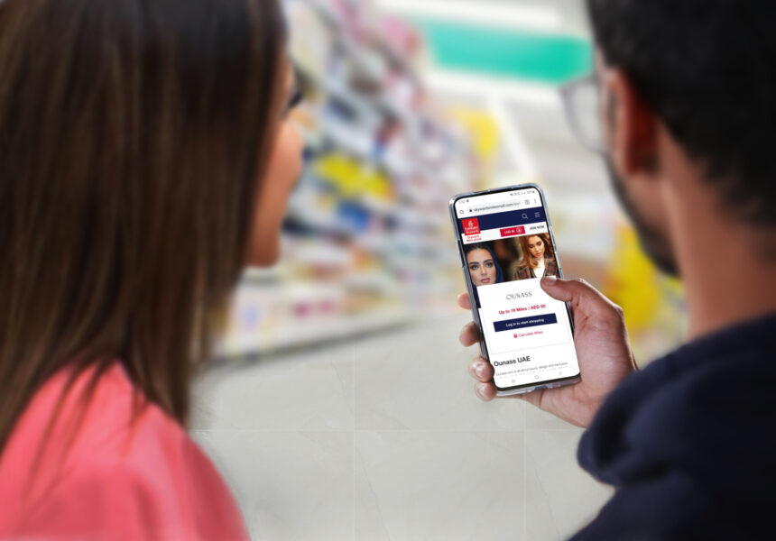 A man and woman, with only the backs of their heads showing, are holding and looking at a phone