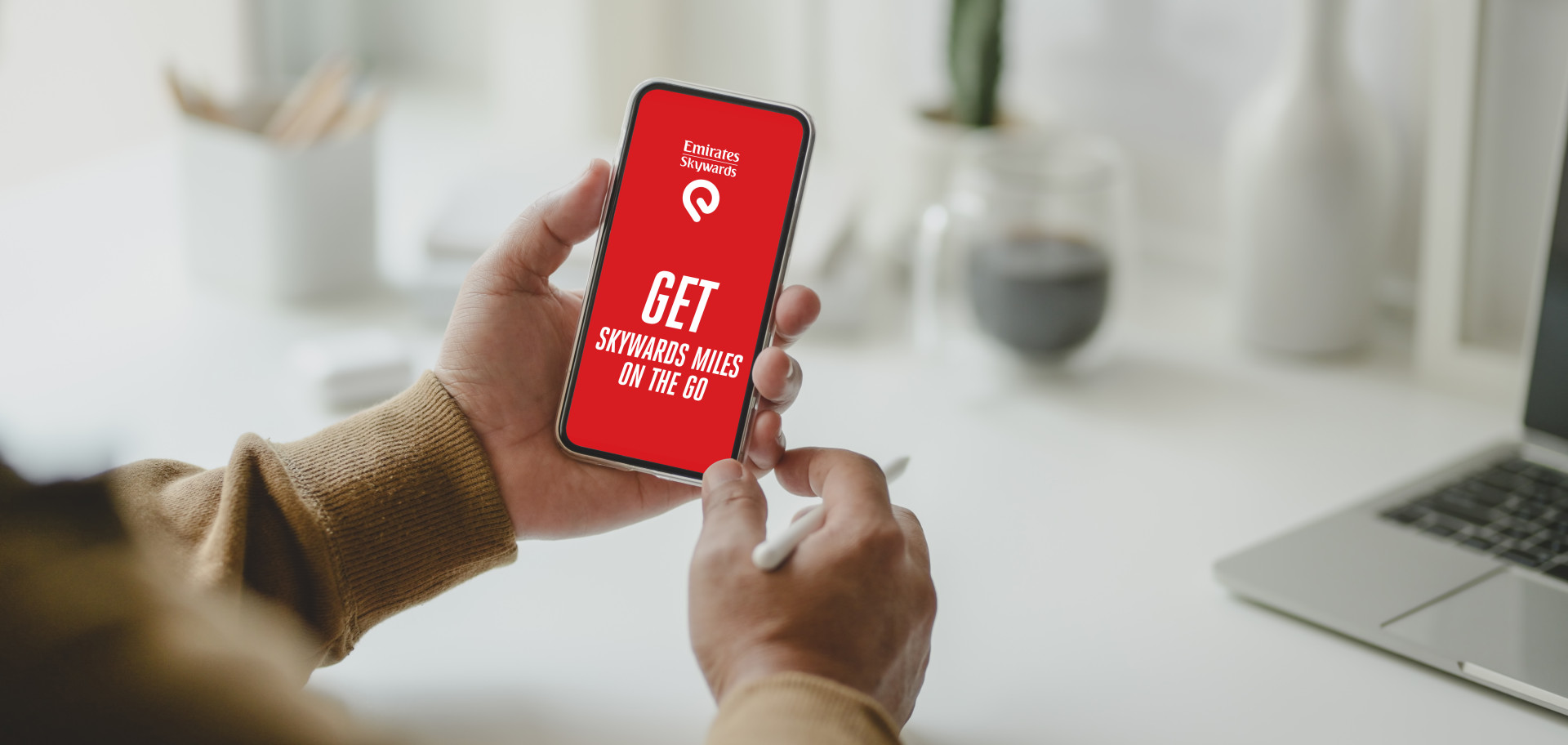 An image of hands holding a phone with a red screen