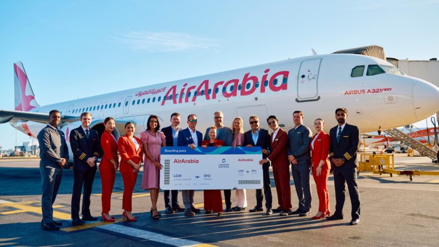 An image of Gatwick and Air Arabia employees holding a large boarding pass standing in front of a Air Arabia aircraft