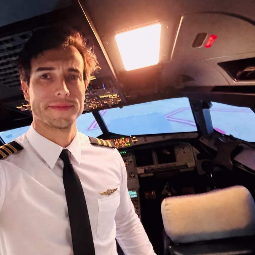 a selfie of Leandro Bertazzo in the cockpit of an aircraft wearing pilot uniform and smiling