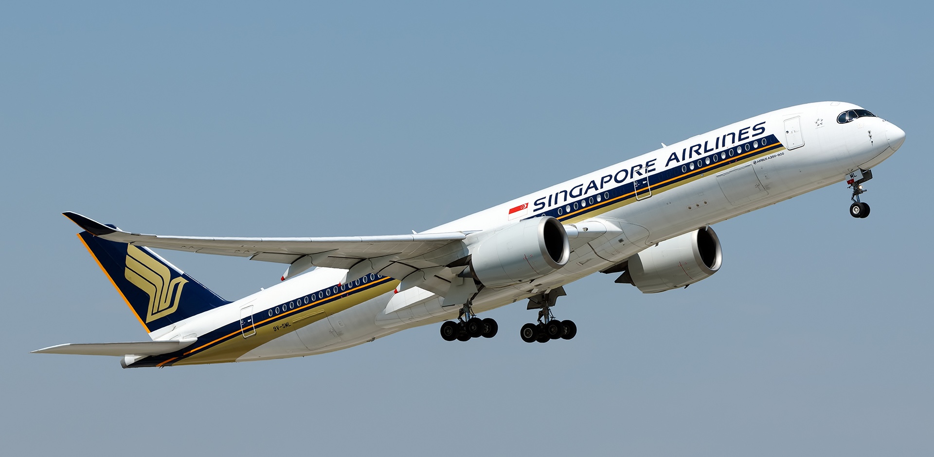 Side view of Singapore Airline's 9V-SML during take off against a clear blue sky with its landing gear still extended.