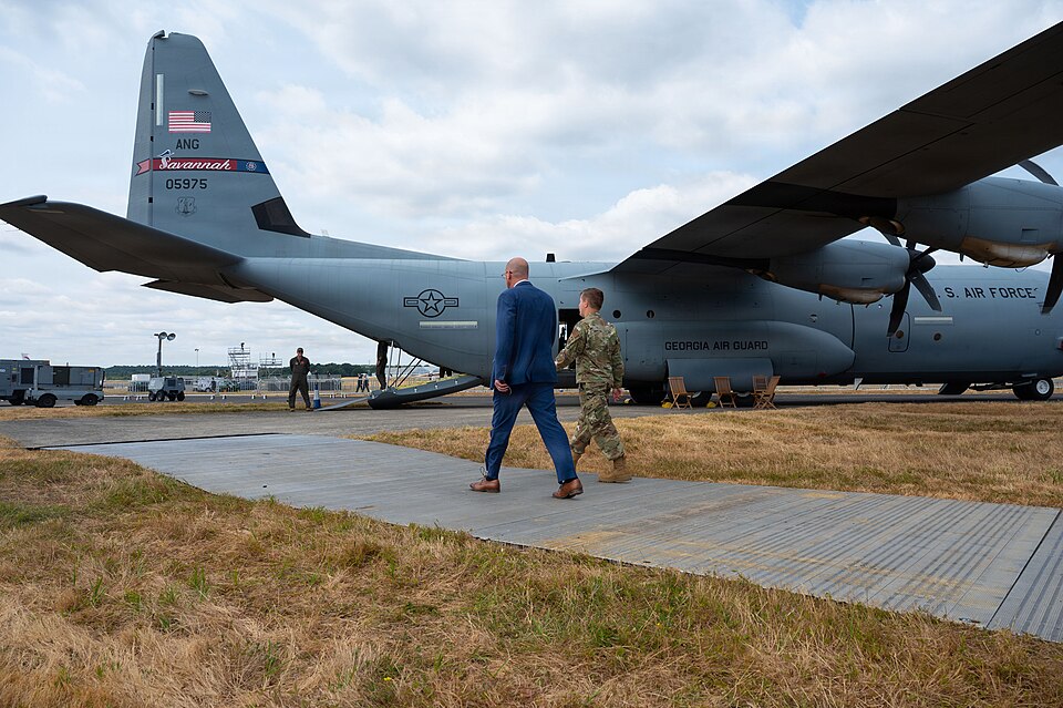 A U.S. Air Force C-130 Hercules transport aircraft from the Georgia Air National Guard on display at the Farnborough International Airshow as visitors approach the rear ramp.
