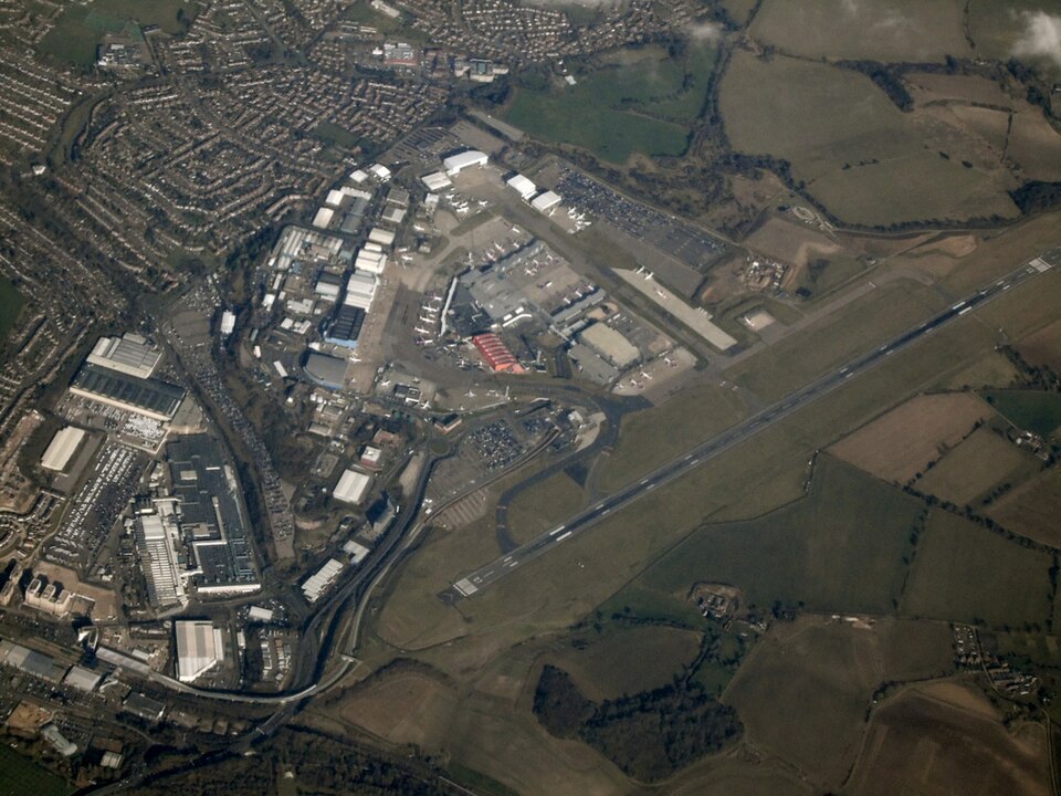 Luton Airport seeing from the sky. One can see the runways and the terminal surrounded by land.