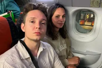 Two passengers (Sammy on the right, Raiff on the left) seated next to a cabin window on an EasyJet flight that was stuck on the tarmac.