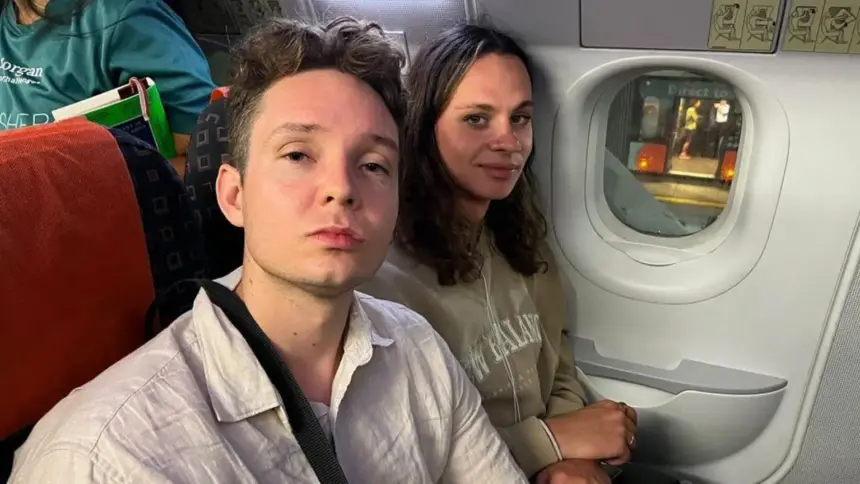 Two passengers (Sammy on the right, Raiff on the left) seated next to a cabin window on an EasyJet flight that was stuck on the tarmac.