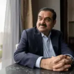 Gautam Adani looks pensive as he stares out the window with his hands interlocked on the table.