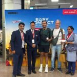 Customers stand with Air India staff to greet the press as part of the Air India 'Easy Connect' service via Amritsar.