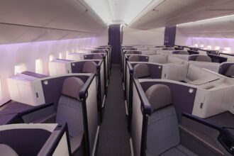Aeroplane interior aisle view, with rows of Business class seats on either side