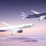 Two Riyadh Air Airbus A350-1000s flying side by side over some mountains
