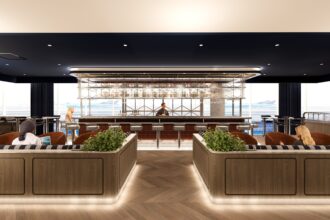 The British Airways' redesigned Newark lounge. A bar in the middle with booths on both sides.