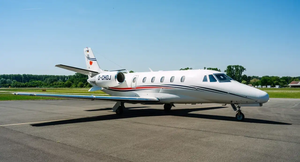 A Silver Cloud Air Cessna Citation XLS. Classic white livery, with blue and red stripes. Blue sky in the background.