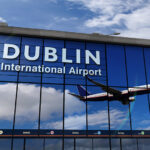Pane taking off in the reflection of Dublin Airport windows.