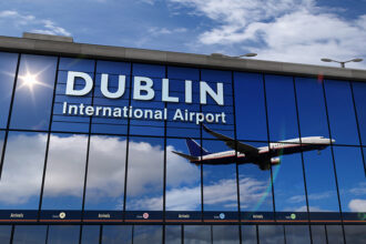 Pane taking off in the reflection of Dublin Airport windows.